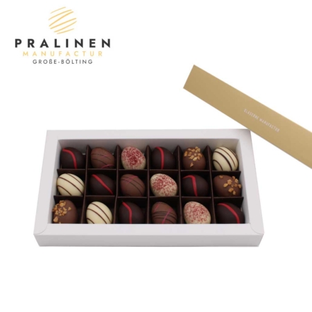 18 Trüffel-Pralinen in Ei-Form in einer hellen Pralinenschachtel